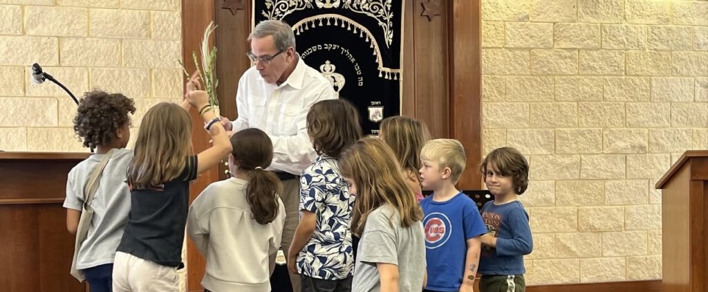 Man reading to a group of children in a cozy room.