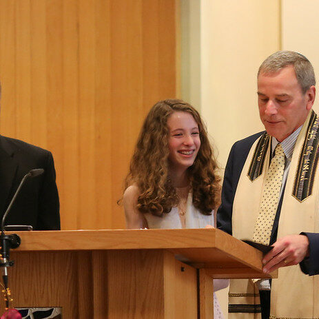 A man and a young woman stand at a podium during a formal ceremony.