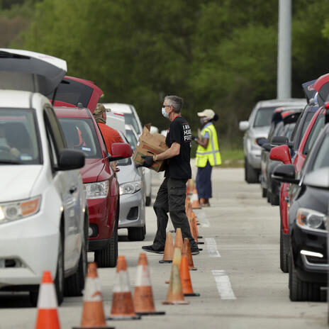 Virus Outbreak Texas Food Drive Workers and volunteers help load cars with food at a San Antonio Food Bank drive-through distribution in San Antonio, Tuesday, April 7, 2020. The new coronavirus causes mild or moderate symptoms for most people, but for some, especially older adults and people with existing health problems, it can cause more severe illness or death. (AP Photo/Eric Gay)