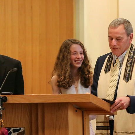 A young girl reading from a podium during a religious ceremony.